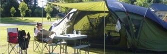 A woman relaxing by her tent